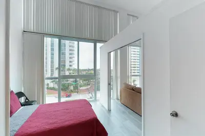 a bedroom with a bed and a large window at Castle Beach: Rumba Suite in Miami Beach