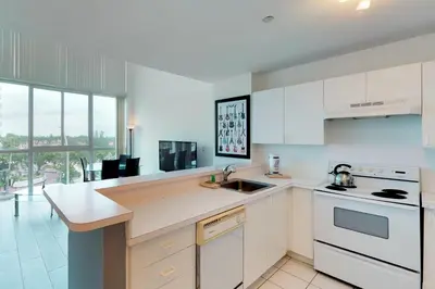 a kitchen with white appliances and a large window at Castle Beach: Rumba Suite in Miami Beach