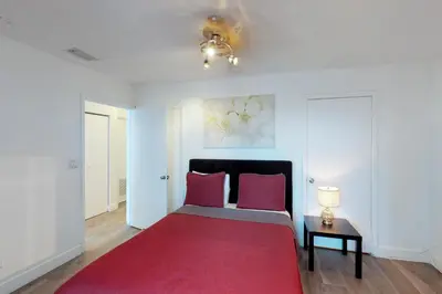a bedroom with a red bed with a red rug at Castle Beach: Rumba Suite in Miami Beach