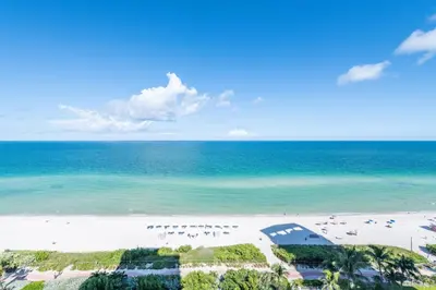 an aerial view of a beach with people in the water at Bluebird Suites Monte Carlo Miami Beach in Miami Beach