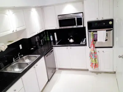 a white kitchen with a sink and a microwave at On The Beach - Lux 2 Bedroom Miami in Hollywood