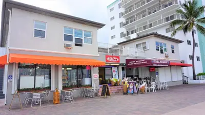 a building with tables and chairs on a street at Golden Sand Oceanfront in Hollywood