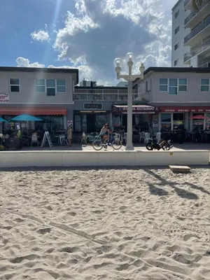 a person riding a bike on the sand on the beach at Golden Sand Oceanfront in Hollywood