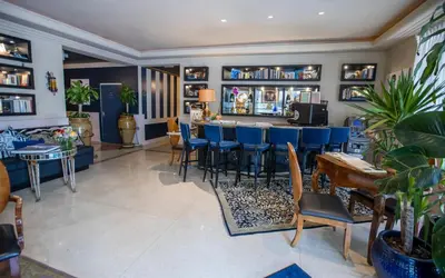 a bar in a restaurant with blue chairs and tables at Riviera Suites in Miami Beach