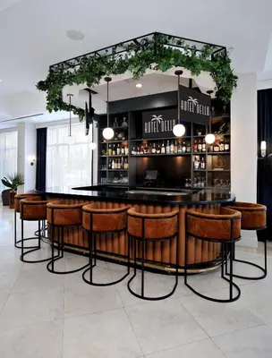 a bar with wooden stools in a room at Hotel Dello Ft Lauderdale Airport, Tapestry Collection by Hilton in Dania Beach