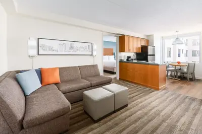 a living room with a couch and a kitchen at Hyatt House Fort Lauderdale Airport/Cruise Port in Dania Beach
