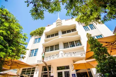 a tall white building with umbrellas in front of it at Iberostar Waves Berkeley Shore in Miami Beach