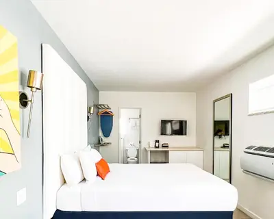 a white bedroom with a bed and a mirror at Royal Palms Resort & Spa in Fort Lauderdale