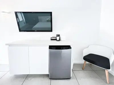 a white desk with a tv and a chair at Royal Palms Resort & Spa in Fort Lauderdale