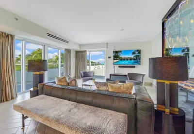 a living room with a brown leather couch at The Sagamore Hotel South Beach in Miami Beach