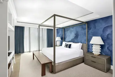 a bedroom with a canopy bed and a blue wall at The Ritz-Carlton Coconut Grove, Miami in Miami
