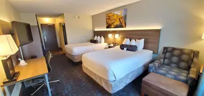 a hotel room with two beds and a chair at Best Western Plus Hollywood/Aventura in Hollywood