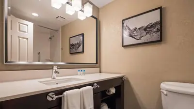 a bathroom with a sink and a mirror and a toilet at Best Western Plus Hollywood/Aventura in Hollywood