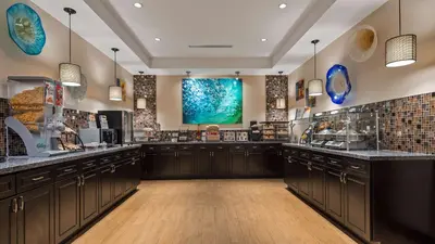 a large kitchen with wooden cabinets and a large window at Best Western Plus Hollywood/Aventura in Hollywood