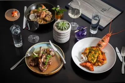 a table with plates of food and glasses of wine at Kimpton EPIC Hotel by IHG in Miami