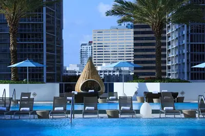 a swimming pool with lounge chairs and a swimming poolvisorvisorvisor at Kimpton EPIC Hotel by IHG in Miami