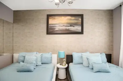two beds with blue pillows in a room at Apartment On The Beach in Miami Beach