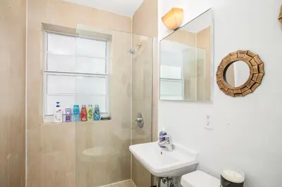 a bathroom with a sink and a toilet and a mirror at Apartment On The Beach in Miami Beach