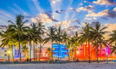 a group of palm trees in front of a building at Pousada Suites at Hollywood Beach in Hollywood