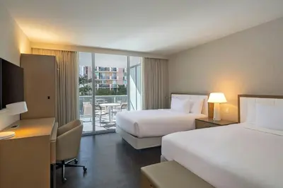 a hotel room with two beds and a desk at Residence Inn Miami Sunny Isles Beach in Miami Beach
