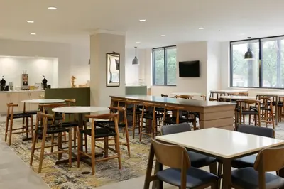 a dining room with tables and chairs and windows at Fairfield Inn & Suites by Marriott Miami Airport South in Miami