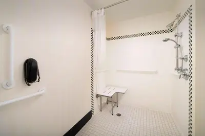 a bathroom with a shower with a bench in it at Fairfield Inn & Suites by Marriott Miami Airport South in Miami