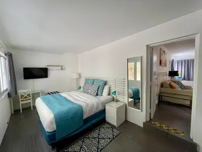 a bedroom with a bed and a mirror at Nobleton Hotel in Fort Lauderdale