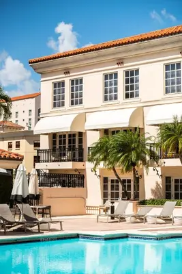 a pool in front of a building with chairs and umbrellas at Hyatt Regency Coral Gables in Miami in Miami