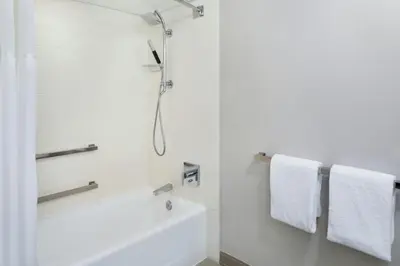 a white bathroom with a shower and a tub at Miami Airport Marriott in Miami