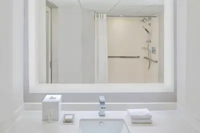 a white bathroom with a sink and a shower at Miami Airport Marriott in Miami