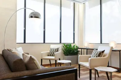 a living room with a couch and chairs and windows at Miami Airport Marriott in Miami