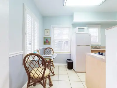 a kitchen with a table and chairs and a refrigerator at The Grand Resort and Spa & Worthington All Male in Fort Lauderdale