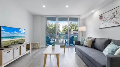 a living room with a couch and a flat screen tv at Family getaway in Sunny Isles - 2nd floor in Miami Beach
