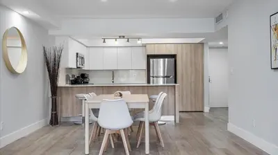 a kitchen and dining room with a table and chairs at Family getaway in Sunny Isles - 2nd floor in Miami Beach