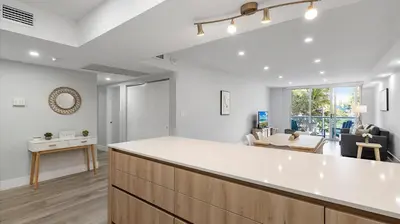 a kitchen and living room with a large white counter top at Family getaway in Sunny Isles - 2nd floor in Miami Beach
