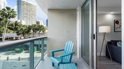 a blue chair on a balcony with a view of the city at Family getaway in Sunny Isles - 2nd floor in Miami Beach