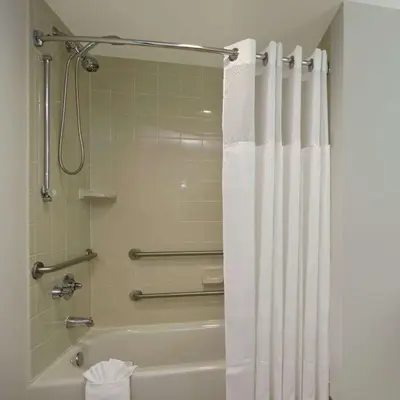 a bathroom with a tub and a shower with a shower curtain at Homewood Suites by Hilton Fort Lauderdale Airport-Cruise Port in Dania Beach