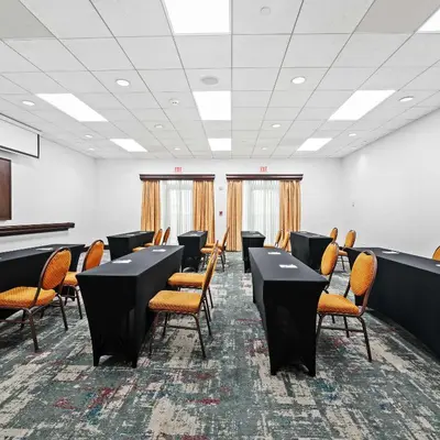 a conference room with black tables and orange chairs at Homewood Suites by Hilton Fort Lauderdale Airport-Cruise Port in Dania Beach