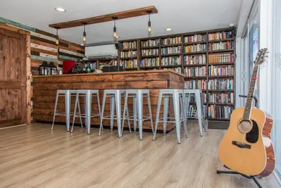 a room with a bar with a guitar and stools at Premiere Hotel in Fort Lauderdale