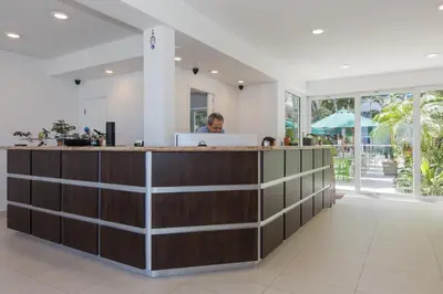 a man is sitting at a reception desk in a lobby at Premiere Hotel in Fort Lauderdale