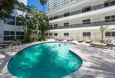 a swimming pool in front of a building at Premiere Hotel in Fort Lauderdale