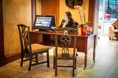 a woman talking on a cell phone at a desk with a computer at The Mutiny Luxury Suites Hotel in Miami