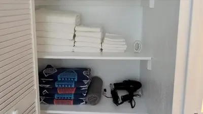a shelf with folded towels and a pile of towels at The Tides-1 bedroom apartment Ground Floor in Hollywood