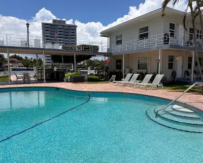 a large swimming pool in front of a house at Holiday Isle Yacht Club in Fort Lauderdale