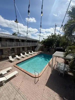 a swimming pool with lounge chairs and a hotel at Sheridan Guesthouse in Dania Beach