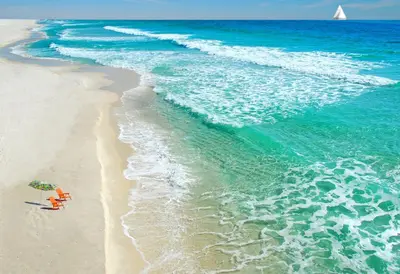 a beach with an umbrella and a chair and the ocean at Barbizon on Ocean Drive Apartments in Miami Beach