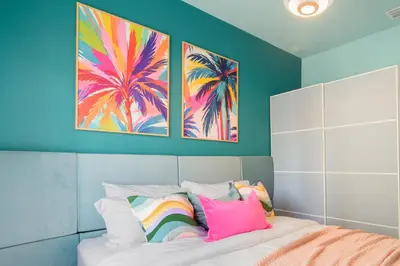 a bedroom with a bed with two paintings on the wall at Barbizon on Ocean Drive Apartments in Miami Beach