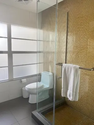a bathroom with a toilet and a glass shower at Hotel Breakwater South Beach in Miami Beach