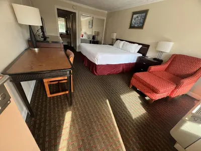 a hotel room with a bed and a red chair at Grand Palms Spa & Golf Resort in Pembroke Pines