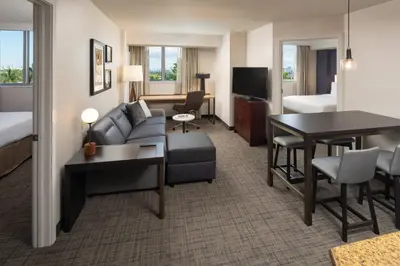 a hotel room with a couch and a table at Residence Inn by Marriott Miami Airport in Miami